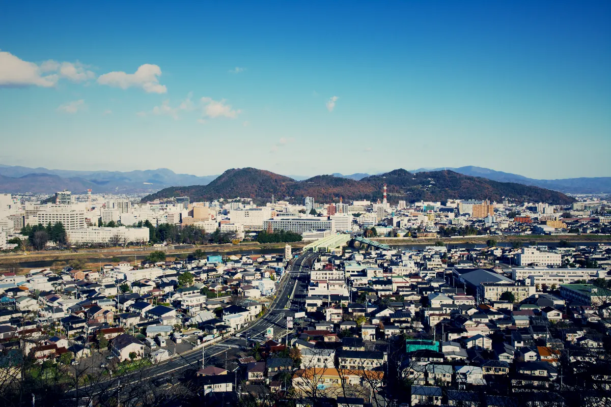 青空の下、山並みを背にした福島市街