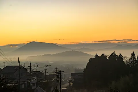 朝霧が流れる山里の夜明け